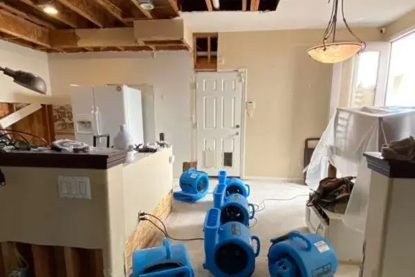Air movers drying a gutted kitchen after water damage in Fullerton